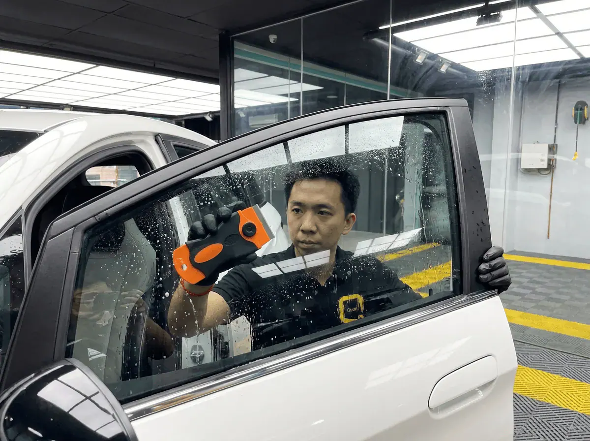 Pembersihan cermin lima peringkat semasa pemasangan tinted pada BYD Dolphin