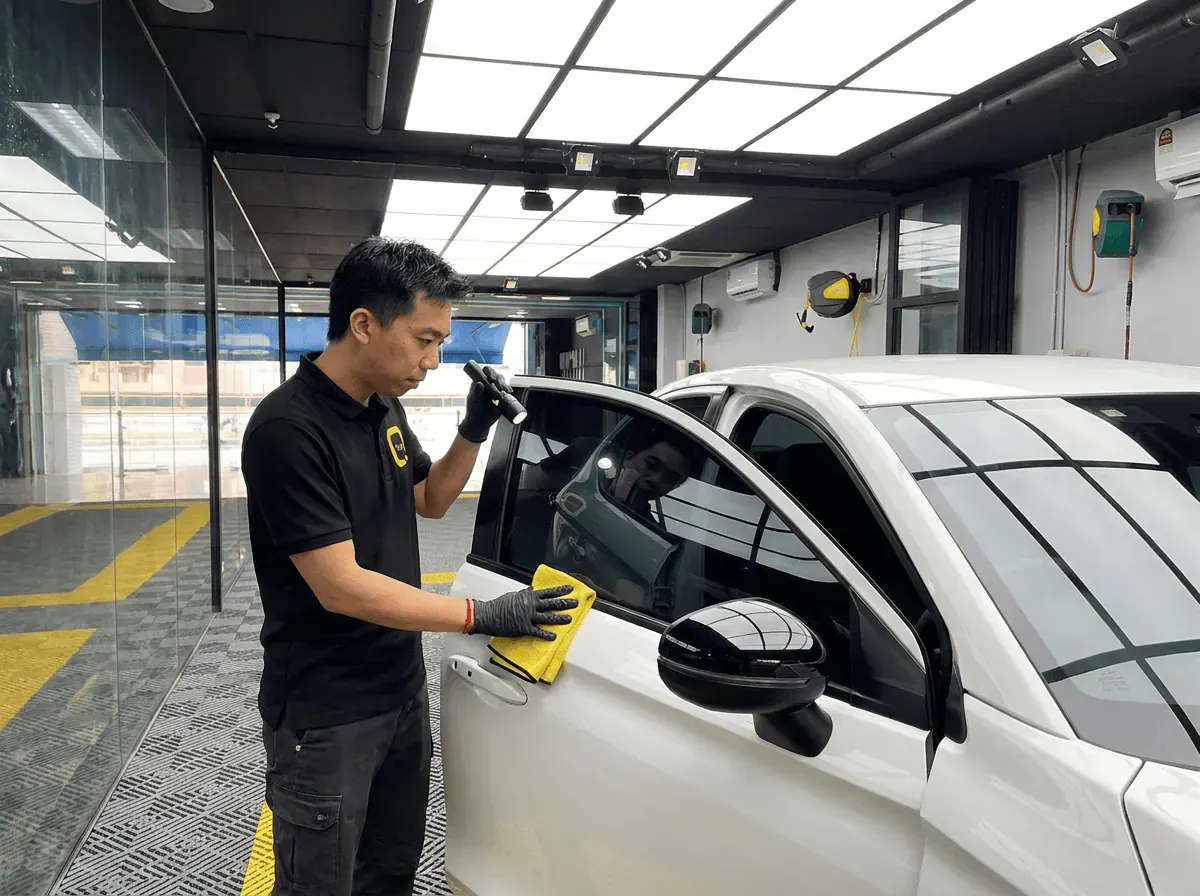Pemeriksaan kualiti dengan lampu suluh semasa pemasangan tinted pada Honda City
