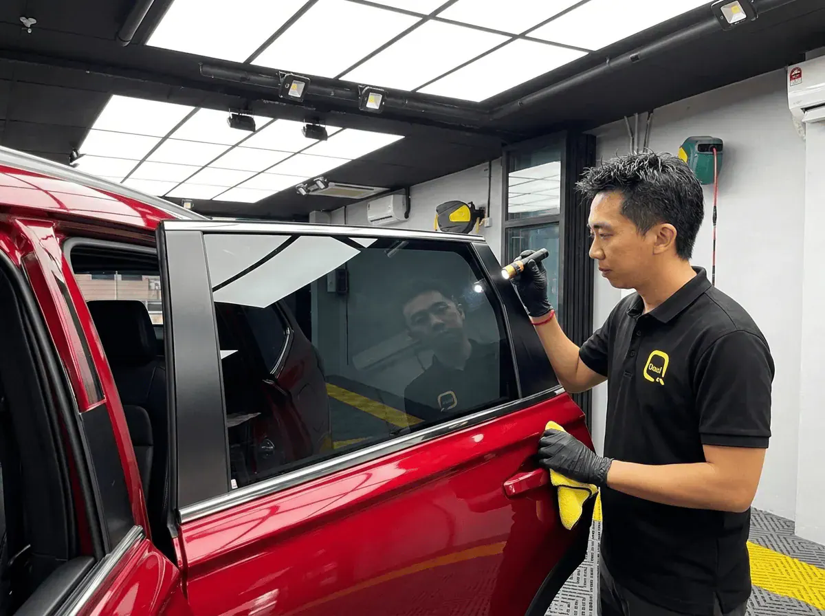 Pemeriksaan kualiti dengan lampu suluh semasa pemasangan tinted pada Honda CR-V
