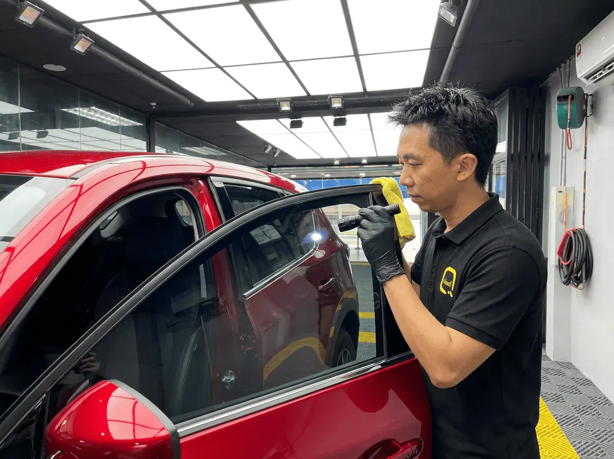 Pemeriksaan kualiti dengan lampu suluh semasa pemasangan tinted pada Mazda CX-5