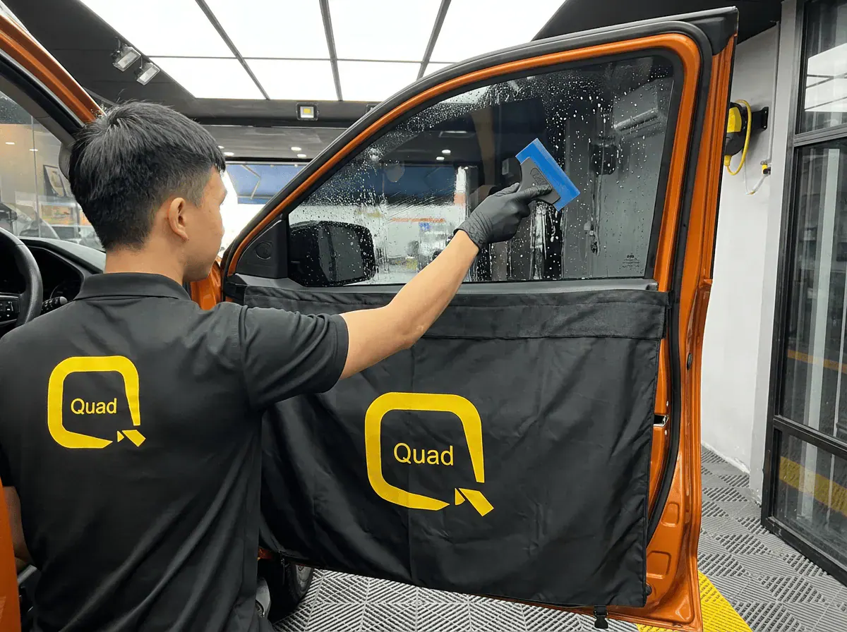Pemasangan filem dan penyingkiran air semasa pemasangan tinted pada Mitsubishi Triton