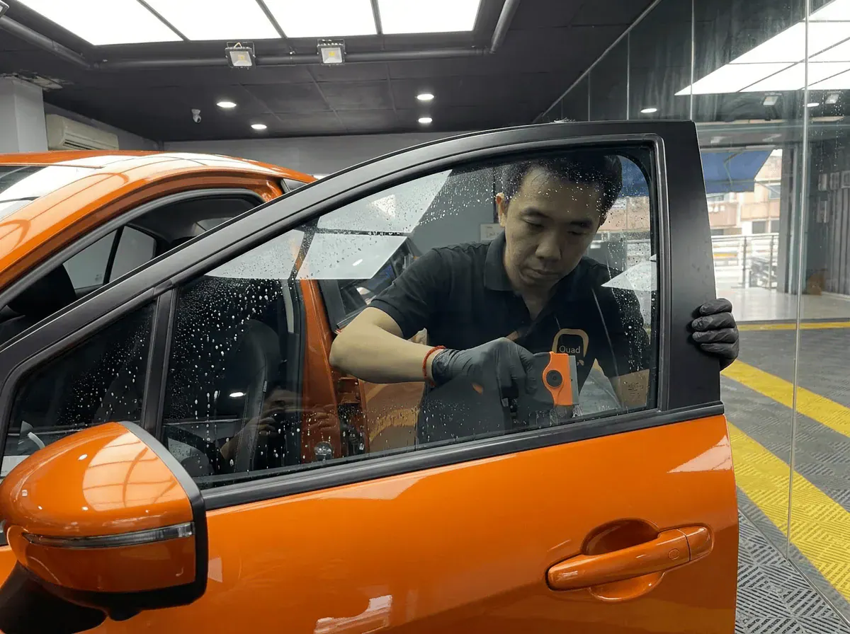 Pembersihan cermin lima peringkat semasa pemasangan tinted pada Nissan Almera