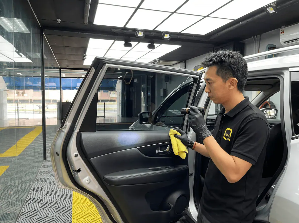 Pemeriksaan kualiti dengan lampu suluh semasa pemasangan tinted pada Nissan X-Trail