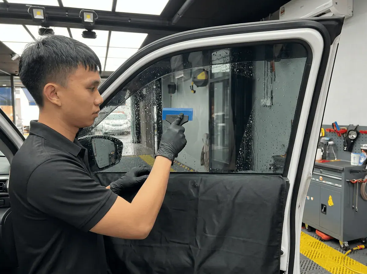 Pemasangan filem dan penyingkiran air semasa pemasangan tinted pada Perodua Ativa