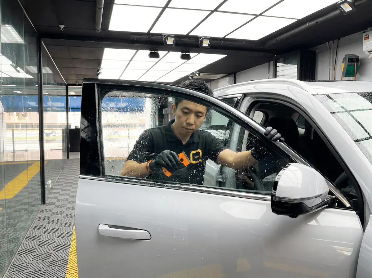 Pembersihan cermin lima peringkat semasa pemasangan tinted pada Proton e.MAS 7