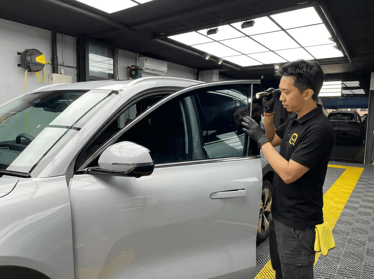 Pemeriksaan kualiti dengan lampu suluh semasa pemasangan tinted pada Proton e.MAS 7