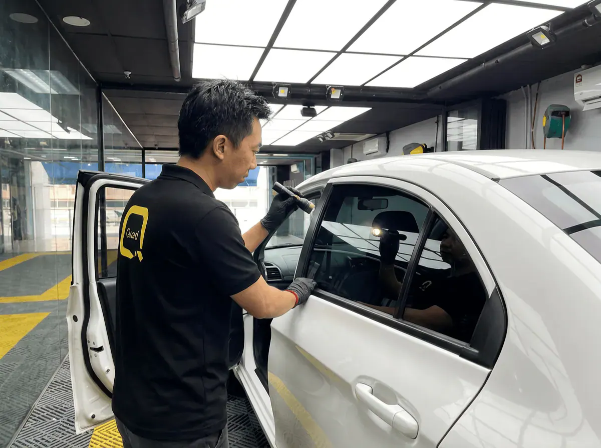 Pemeriksaan kualiti dengan lampu suluh semasa pemasangan tinted pada Proton Saga