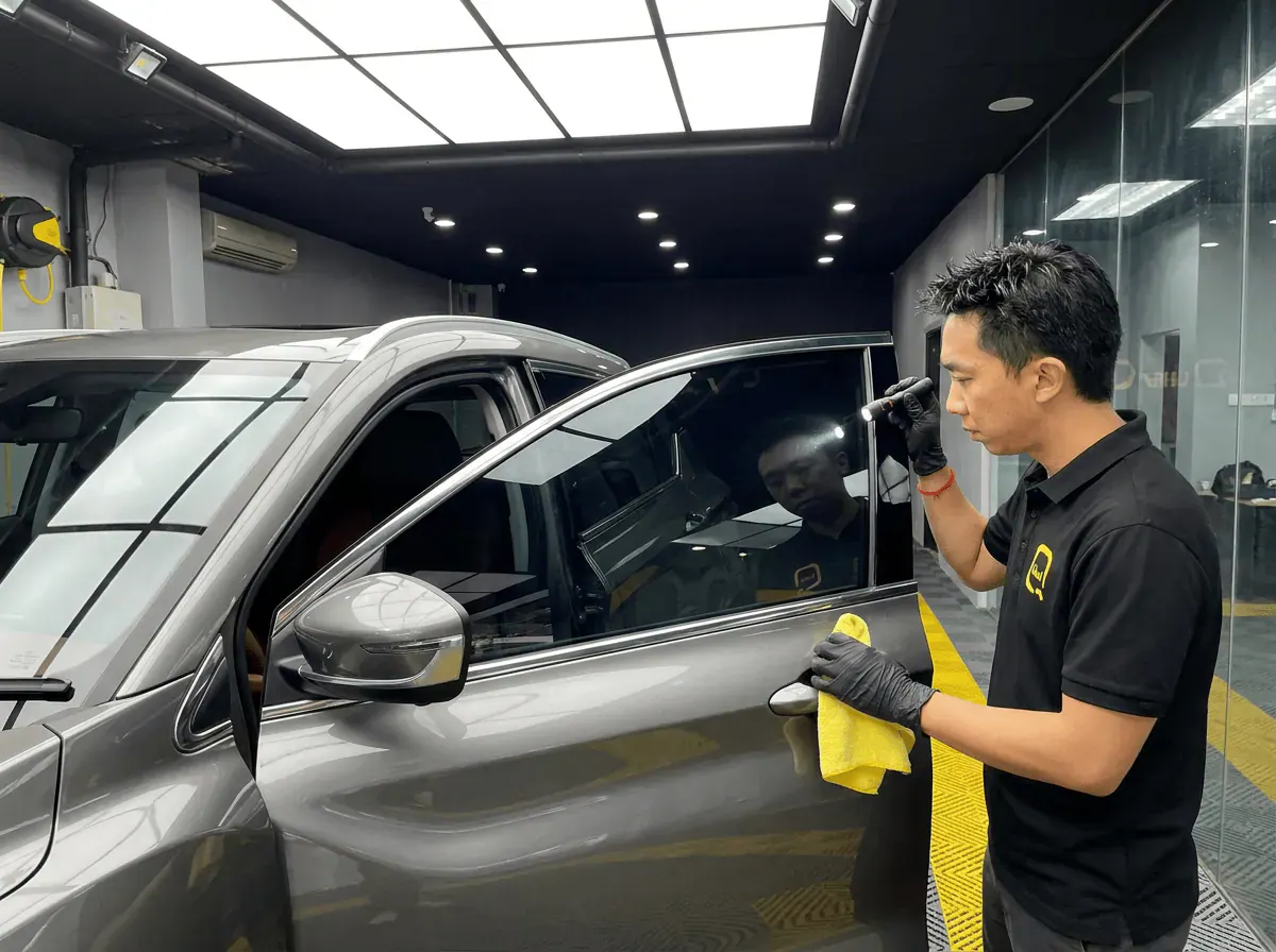 Pemeriksaan kualiti dengan lampu suluh semasa pemasangan tinted pada Proton X50
