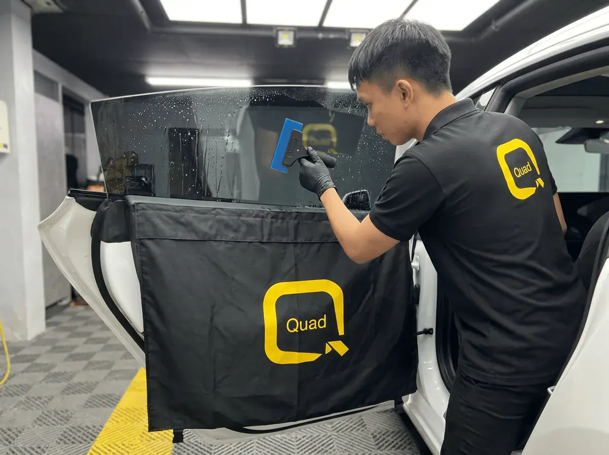 Pemasangan filem dan penyingkiran air semasa pemasangan tinted pada Tesla Model 3