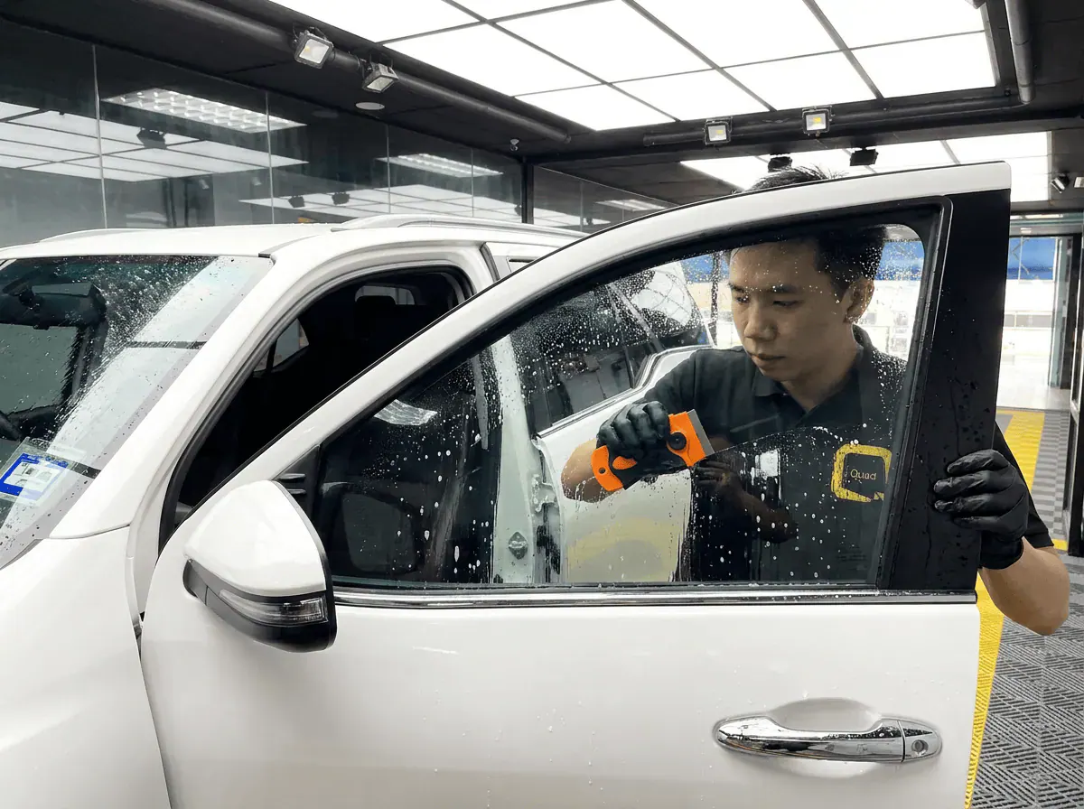Pembersihan cermin lima peringkat semasa pemasangan tinted pada Toyota Fortuner