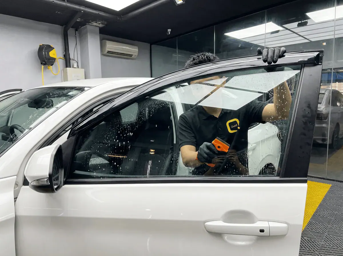 Pembersihan cermin lima peringkat semasa pemasangan tinted pada Toyota Vios