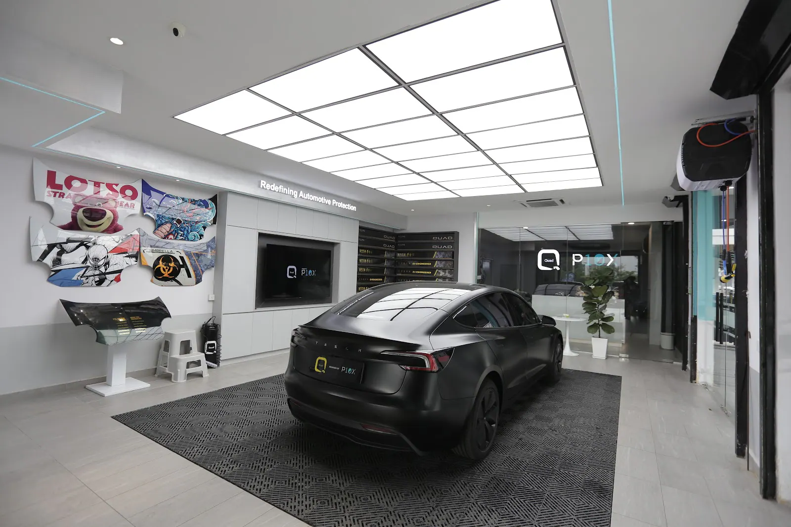 Quad Film showroom interior with a Tesla on display.