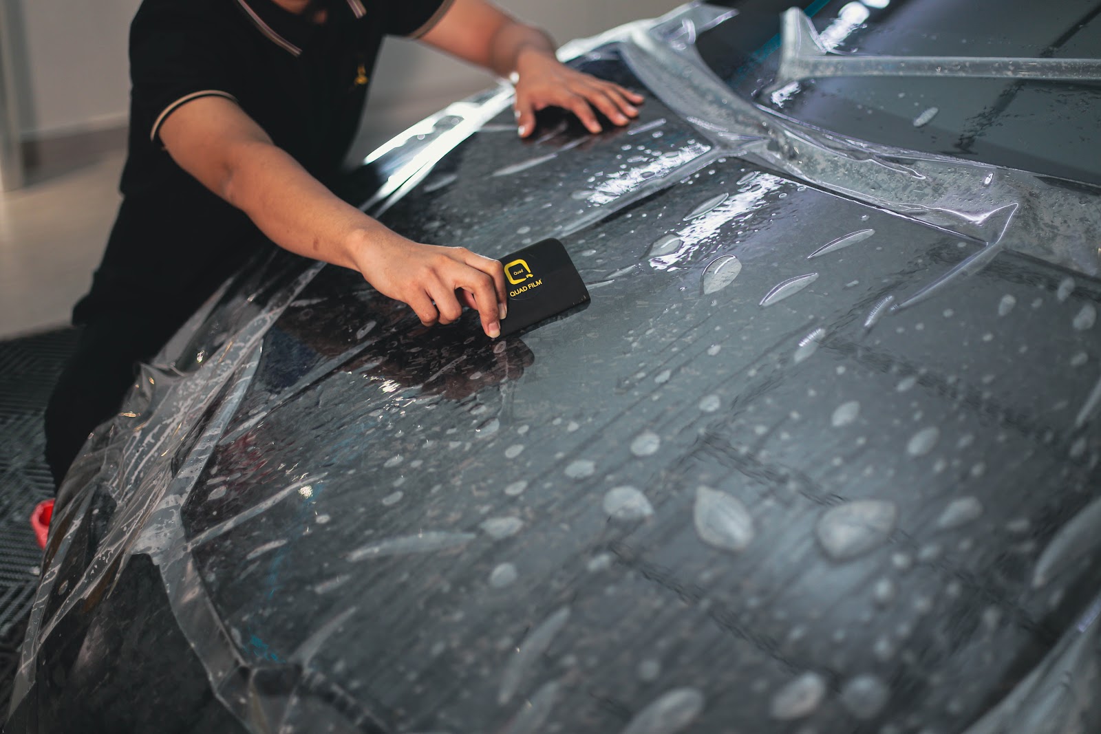 ppf installation black car squeegee technician